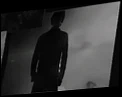 A man in a long coat against fog.