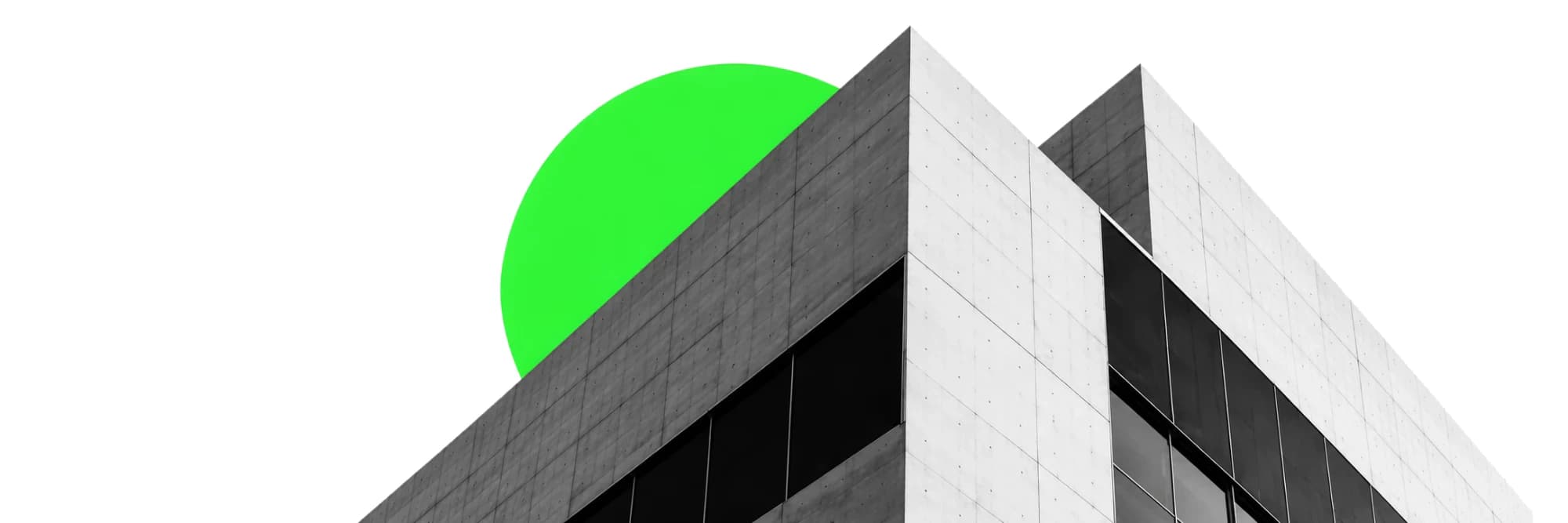 The corner of a concrete office block seen from below, a green disc rising behind its roofline.