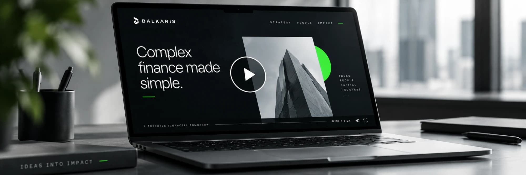 A laptop on a desk playing a Balkaris film, paused on its title “Complex finance made simple.”