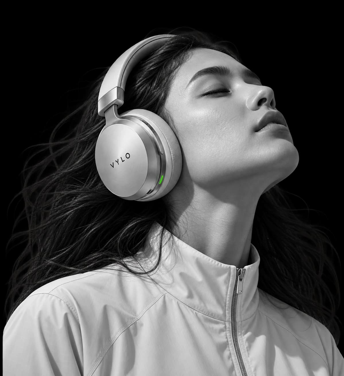 A woman in VYLO headphones, eyes closed and head tilted back, in front of the word “Feel”.