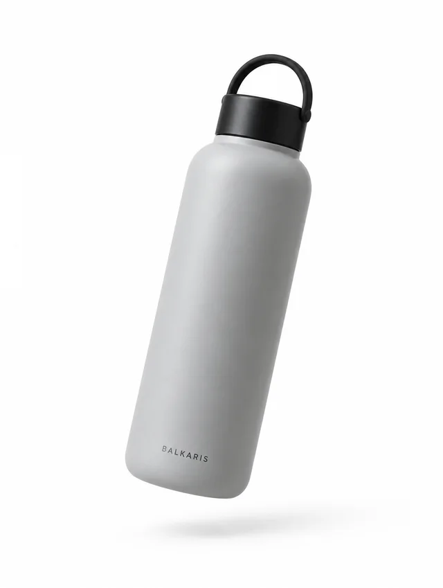 A matte grey insulated bottle with a black cap, floating at a slight tilt.