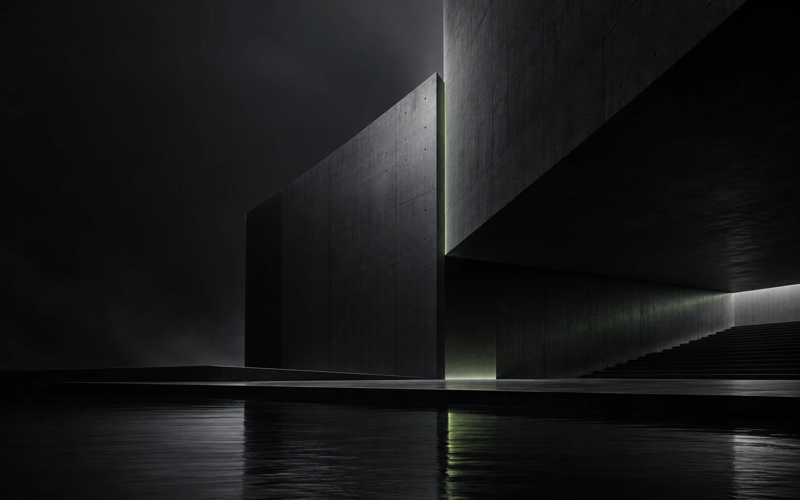 A long concrete building standing over still water at night, one edge of it lit.